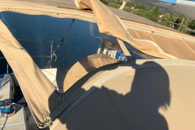 Slide: The Image of Tartan 3400 sailboat cockpit with beige canopy, reflecting water and landscape, 2007 model. - 18