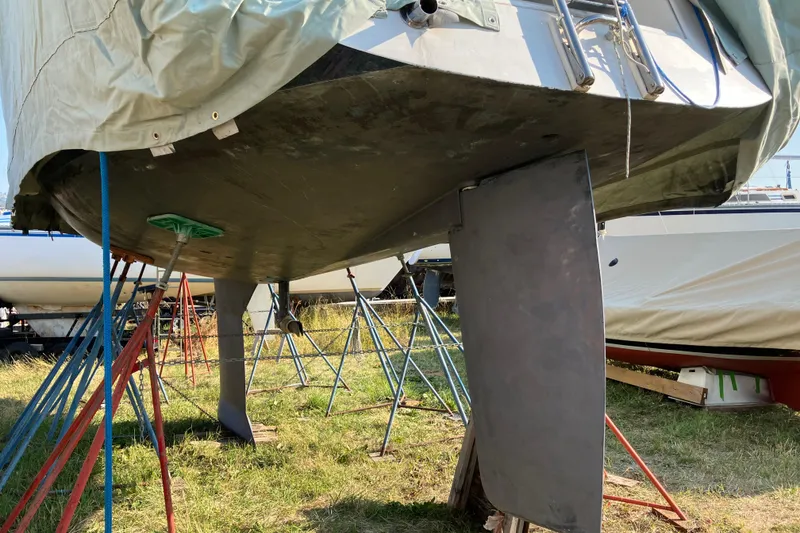 Slide: The Image of Tartan 3400 sailboat from 2007 on stands, under maintenance, with visible keel and rudder. - 33