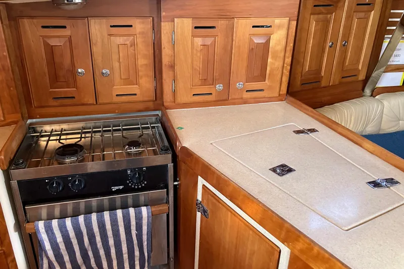 Slide: The Image of Tartan 3400 yacht kitchen with stove and wooden cabinetry, 2007 model. - 37