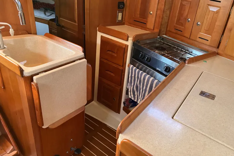 Slide: The Image of 2007 Tartan 3400 yacht kitchen with wooden cabinetry and compact appliances. - 39
