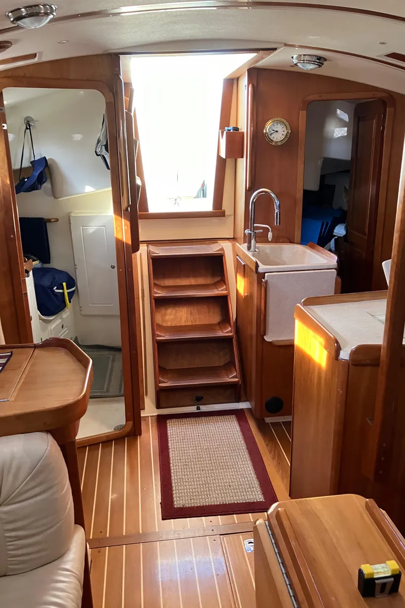 Slide: The Image of Interior of 2007 Tartan 3400 sailboat with wooden finishes and compact kitchen area. - 45