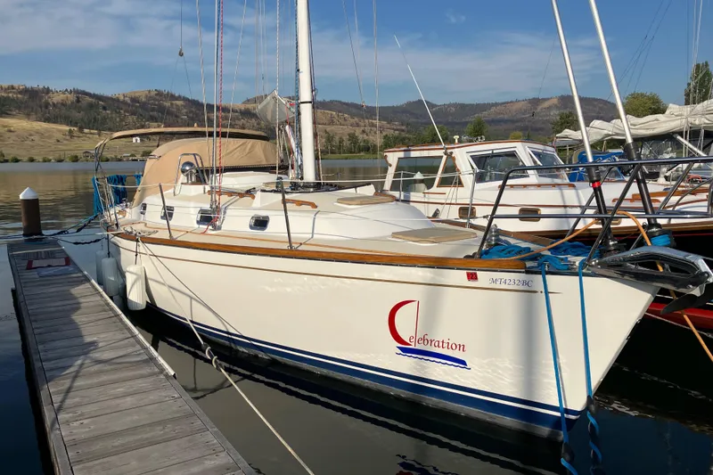 Slide: The Image of 2007 Tartan 3400 sailboat docked at a marina with scenic mountain backdrop. - 7
