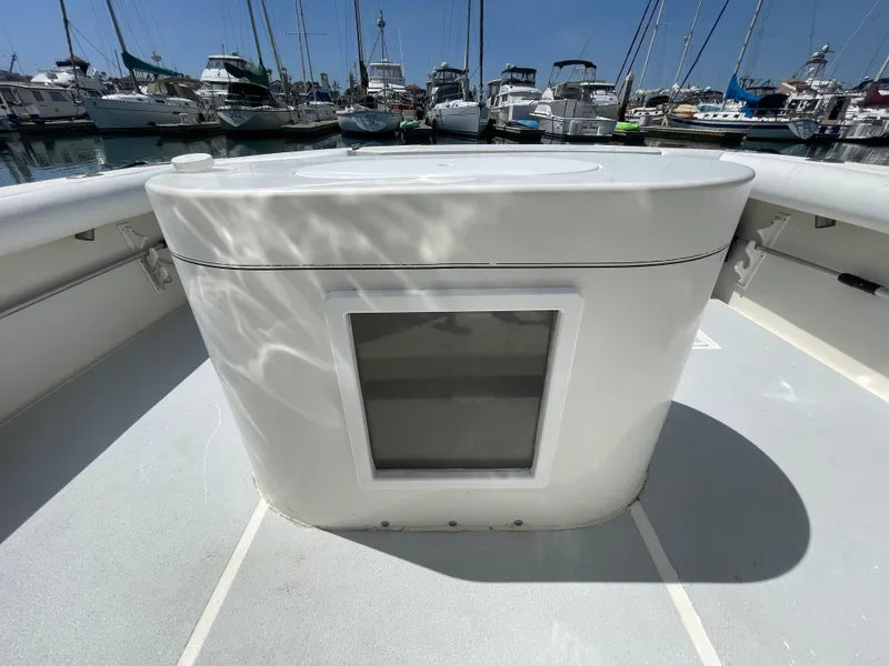 Slide: The Image of 1997 Cabo 31 Express boat deck with storage compartment, docked in marina. - 13
