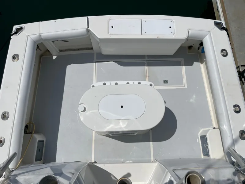 Slide: The Image of 1997 Cabo 31 Express boat deck with central oval table, white seating, and storage compartments. - 14