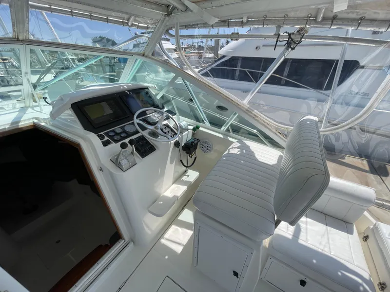 Slide: The Image of 1997 Cabo 31 Express boat cockpit with steering wheel and control panel. - 16
