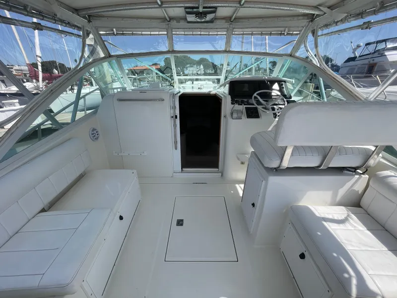 Slide: The Image of 1997 Cabo 31 Express boat interior with white seating and helm station. - 18