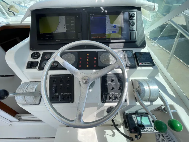 Slide: The Image of Control panel of a 1997 Cabo 31 Express boat with navigation screens and steering wheel. - 20