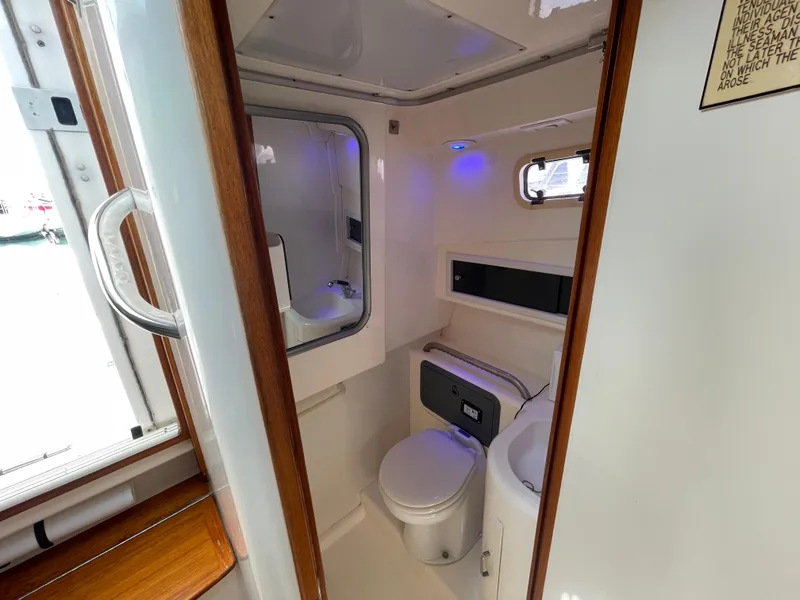 Slide: The Image of 1997 Cabo 31 Express boat bathroom with toilet, sink, and mirror. - 21