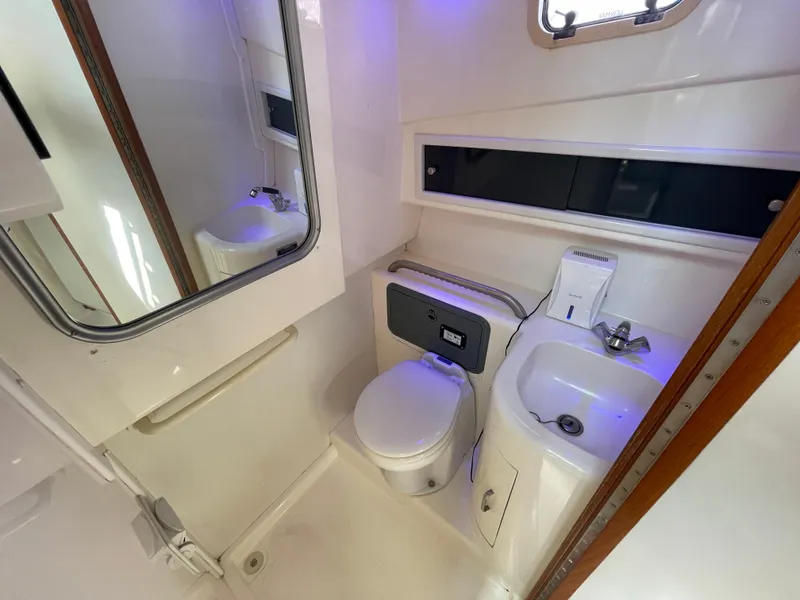Slide: The Image of 1997 Cabo 31 Express boat bathroom with toilet, sink, mirror, and storage. - 22