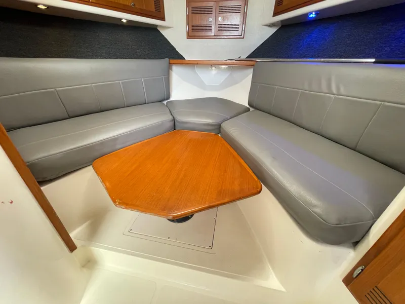 Slide: The Image of Interior of 1997 Cabo 31 Express boat with gray seating and wooden table. - 26