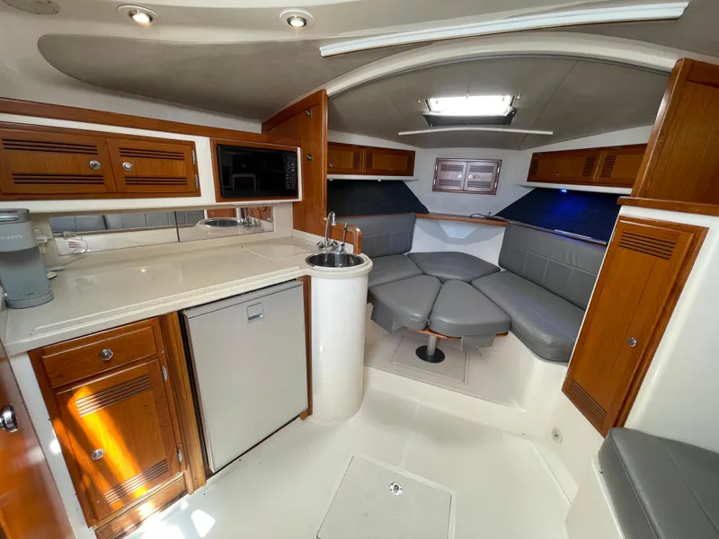 Slide: The Image of Interior of a 1997 Cabo 31 Express boat with kitchenette and seating area. - 33