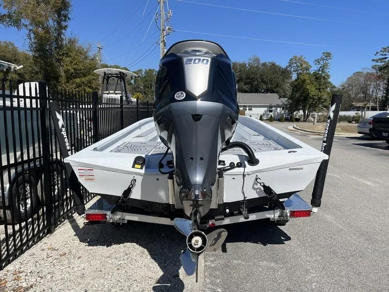 Slide: The Image of 2025 Xpress H22B boat with powerful outboard motor, parked on a sunny day. - 15