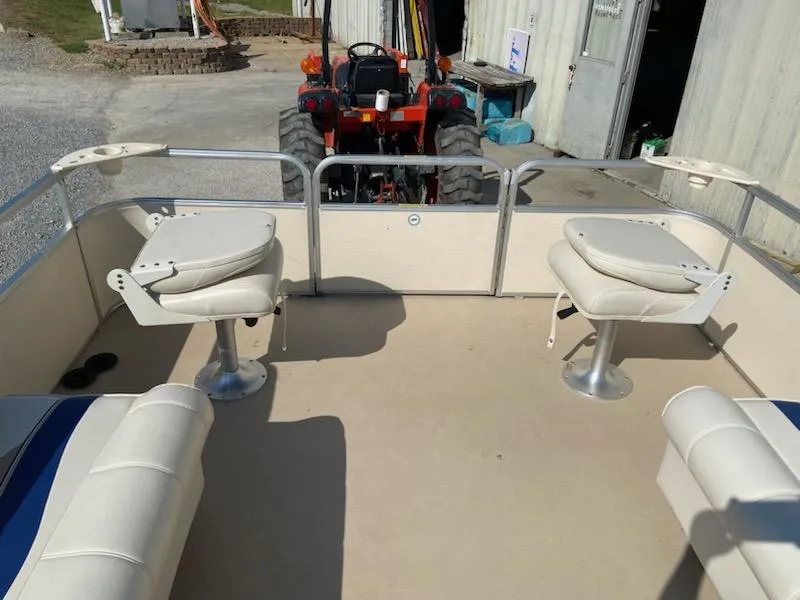 Slide: The Image of 2008 Godfrey Sweetwater SWT 2486 FC pontoon boat interior with seating and tractor in background. - 9