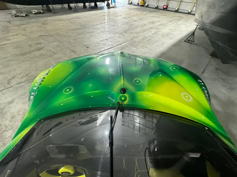 Slide: The Image of 2023 Watersports Car Series B with vibrant green and yellow design in a garage. - 13