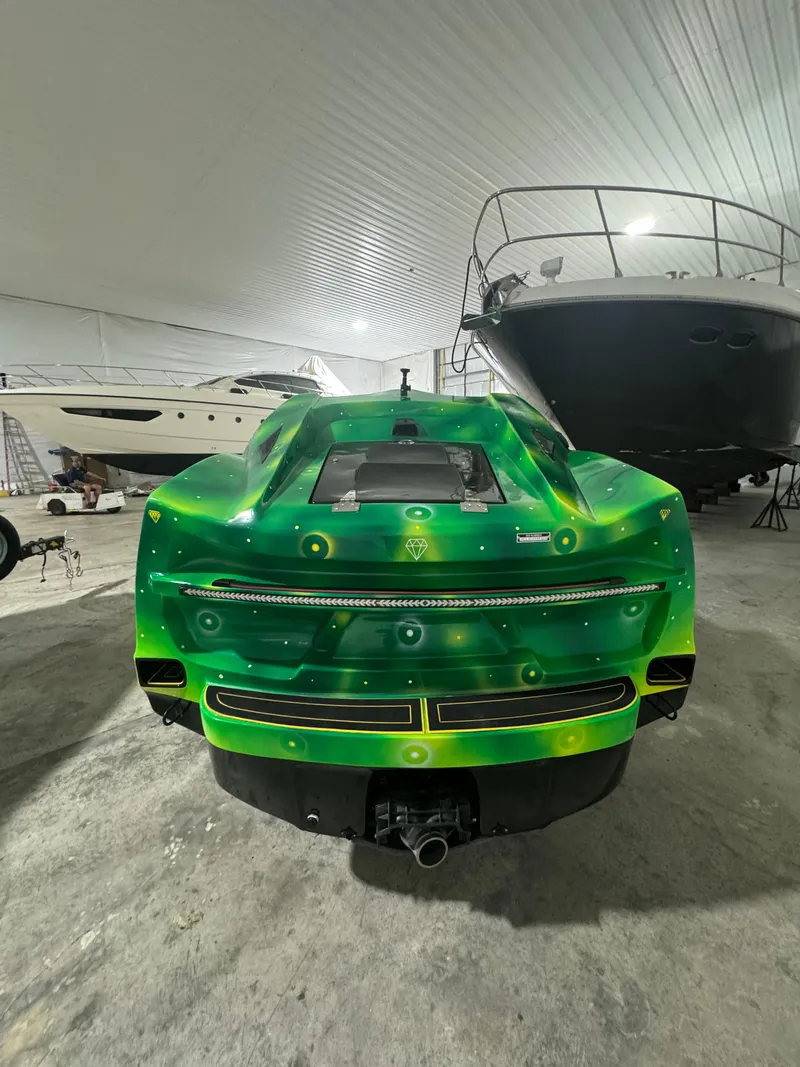 Slide: The Image of 2023 Watersports Car Series B in vibrant green, parked indoors near boats. - 3