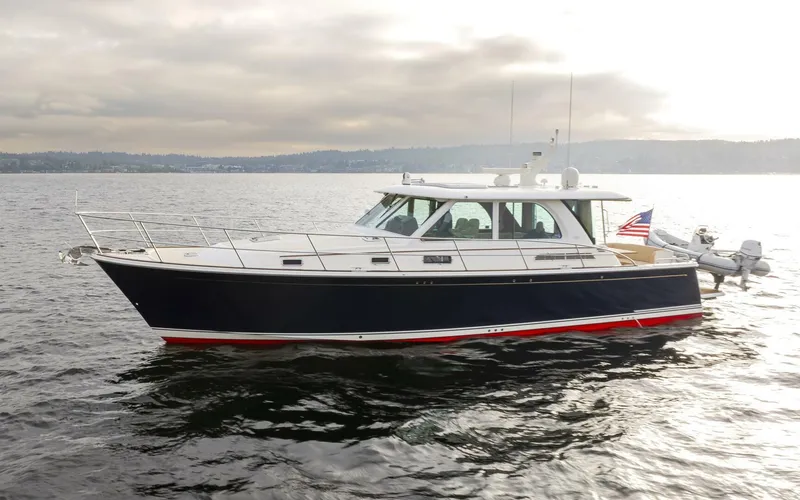 Slide: The Image of 2018 Sabre 45 Salon Express yacht on calm water, showcasing sleek design and American flag. - 1