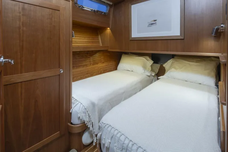 Slide: The Image of Twin cabin interior of 2018 Sabre 45 Salon Express yacht, featuring wooden paneling and cozy bedding. - 15