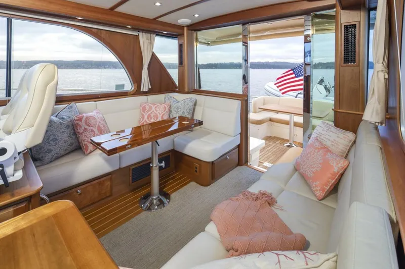 Slide: The Image of 2018 Sabre 45 Salon Express interior with elegant seating, wooden table, and scenic water view. - 17