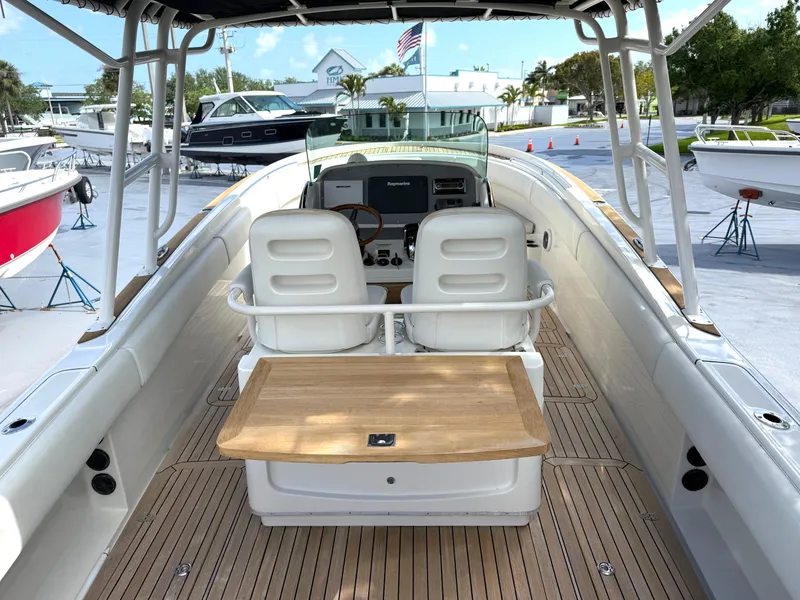Slide: The Image of 2014 Chris-Craft Catalina 29 boat interior with dual seats and wooden deck. - 16