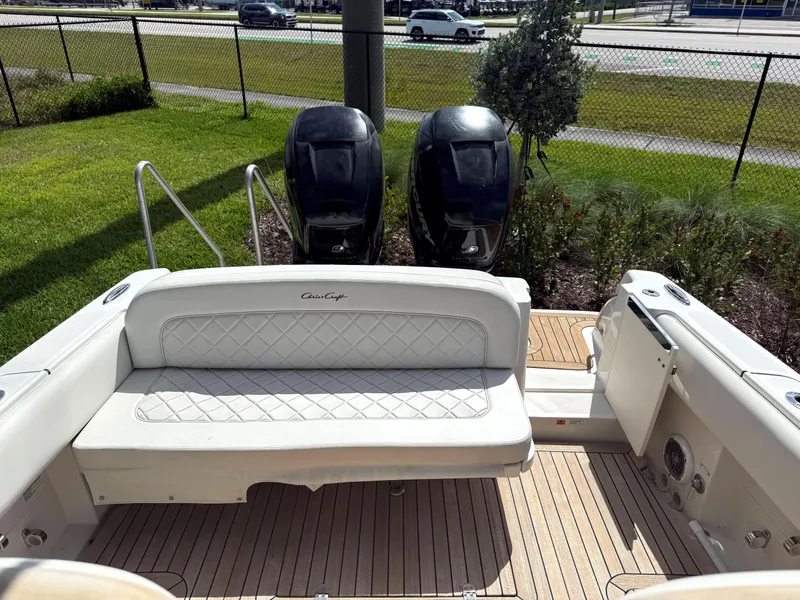 Slide: The Image of 2014 Chris-Craft Catalina 29 boat with dual outboard engines and cushioned seating. - 19