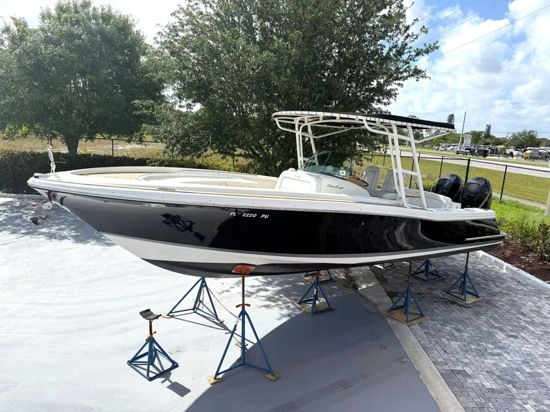 Slide: The Image of 2014 Chris-Craft Catalina 29 boat on stands, outdoors, with trees and sky in background. - 4