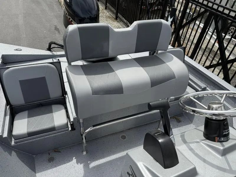 Slide: The Image of 2025 Xpress H20B boat interior with gray seating and steering wheel. - 12
