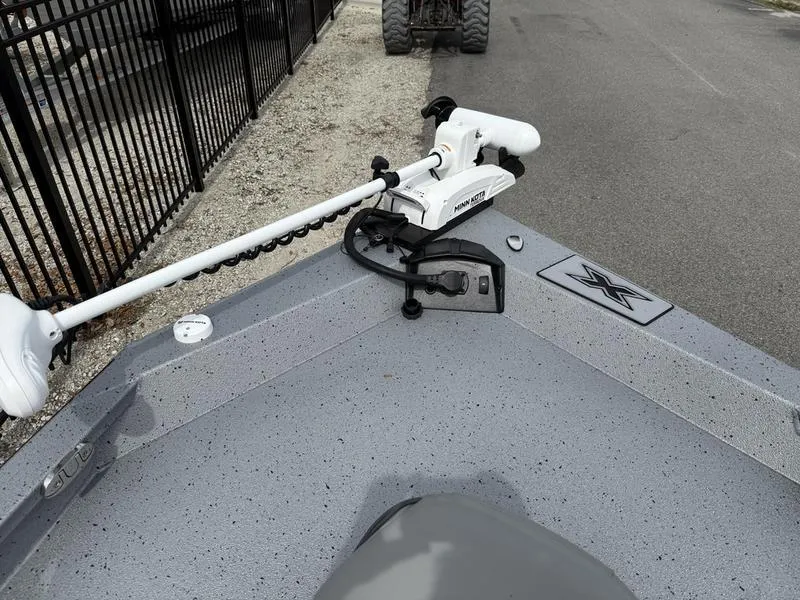 Slide: The Image of 2025 Xpress H20B boat with trolling motor on a speckled gray deck. - 13
