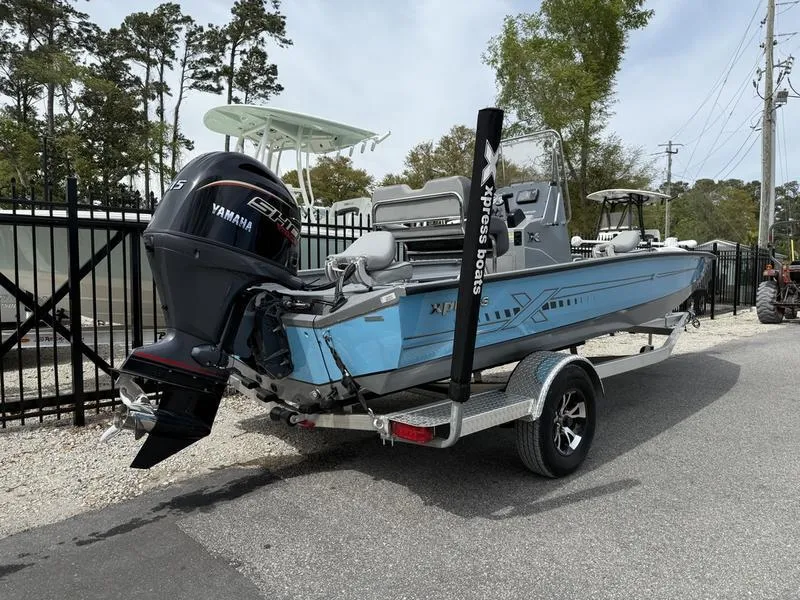 Slide: The Image of 2025 Xpress H20B boat with Yamaha engine on a trailer, parked outdoors. - 4