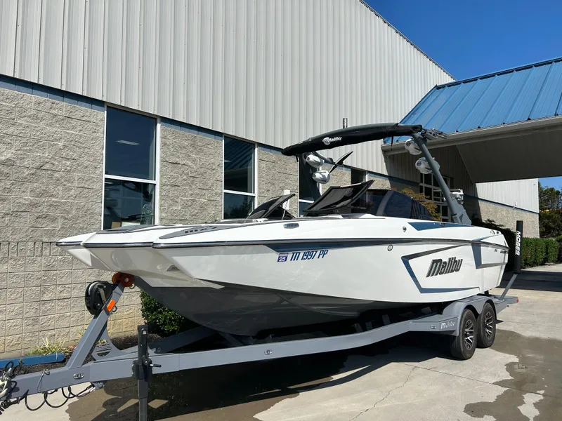 Slide: The Image of 2021 Malibu Wakesetter 24 MXZ boat on trailer outside a building. - 3