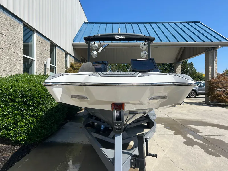 Slide: The Image of 2021 Malibu Wakesetter 24 MXZ boat on trailer, parked outside a building. - 4
