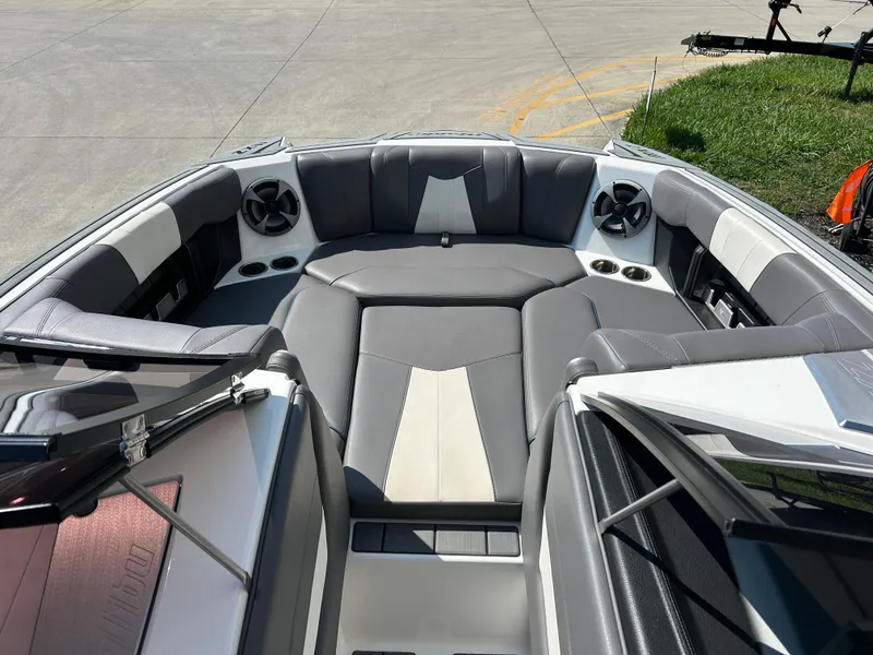 Slide: The Image of 2021 Malibu Wakesetter 24 MXZ boat interior with gray seating and speakers. - 9