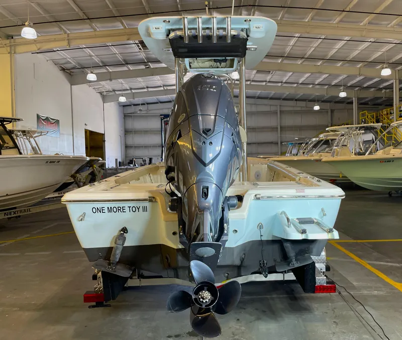 Slide: The Image of 2024 Key West 210 Bay Reef boat in a warehouse, featuring a powerful outboard motor. - 10