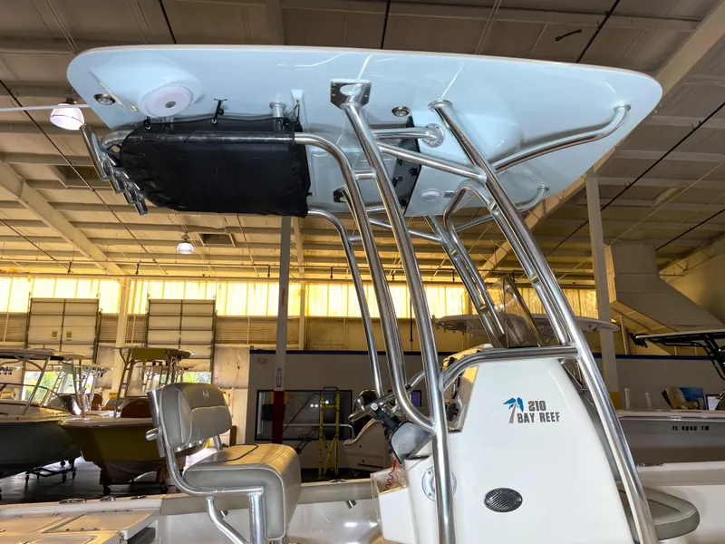 Slide: The Image of 2024 Key West 210 Bay Reef boat interior with T-top and seating in a showroom. - 12