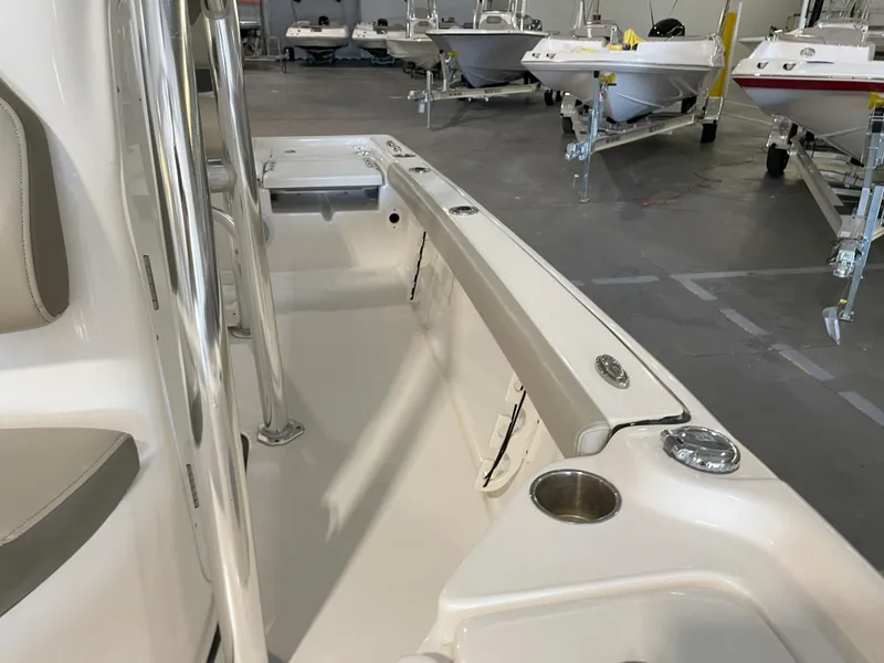 Slide: The Image of 2024 Key West 210 Bay Reef boat interior with seating and cup holders in a showroom. - 25