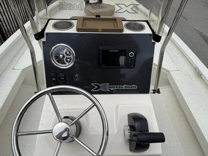 Slide: The Image of 2025 Xpress H20B boat console with steering wheel, gauges, and controls. - 10