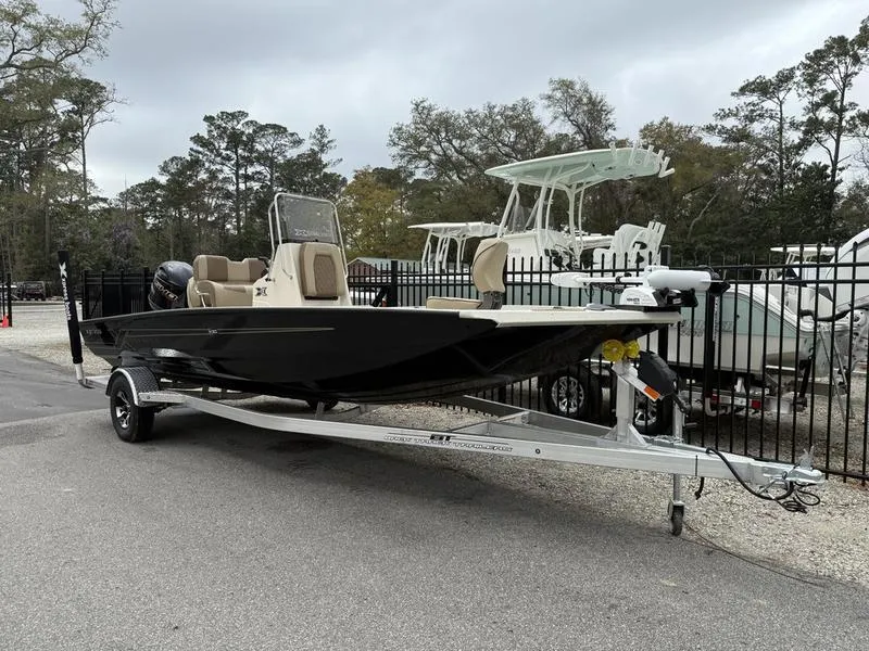 Slide: The Image of 2025 Xpress H20B boat on trailer, parked outdoors near other boats. - 3