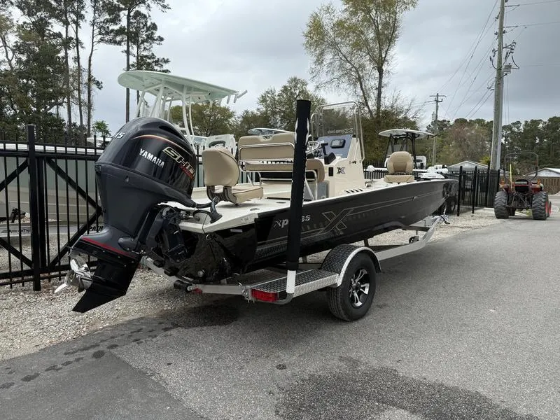 Slide: The Image of 2025 Xpress H20B boat with Yamaha engine on trailer, parked outdoors. - 4