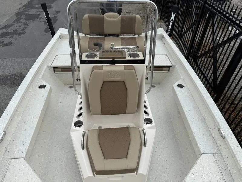 Slide: The Image of 2025 Xpress H20B boat interior with beige seating and console, showcasing modern design. - 8