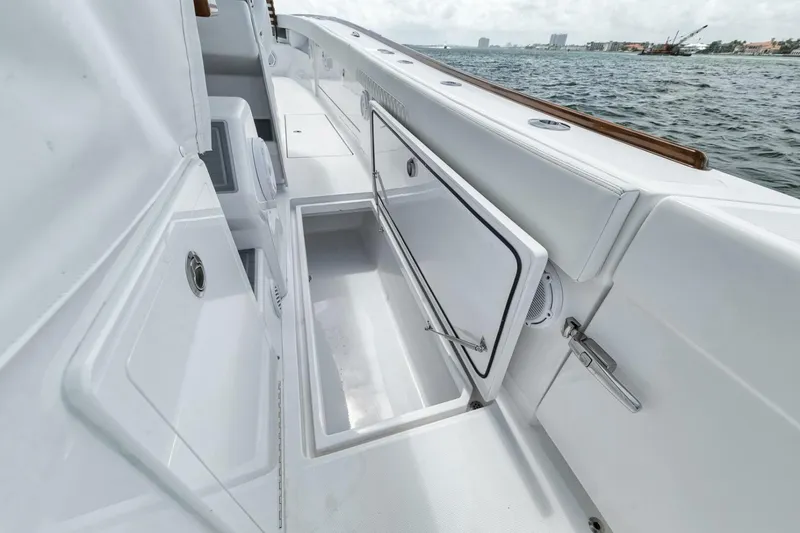 Slide: The Image of 2024 Front Runner 47 Center Console boat with open storage compartments by the water. - 26