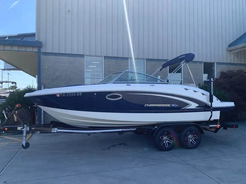 Slide: The Image of 2012 Chaparral 224 Sunesta boat on trailer, parked outside a building. - 1