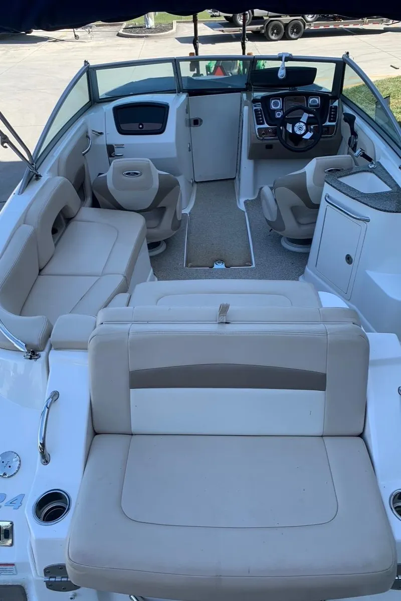 Slide: The Image of 2012 Chaparral 224 Sunesta boat interior with beige seating and modern dashboard. - 2