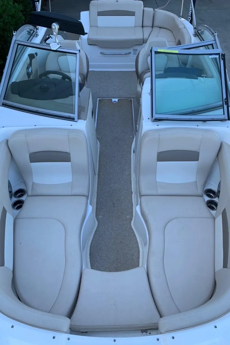 Slide: The Image of 2012 Chaparral 224 Sunesta boat interior with beige seating and open windshield. - 3