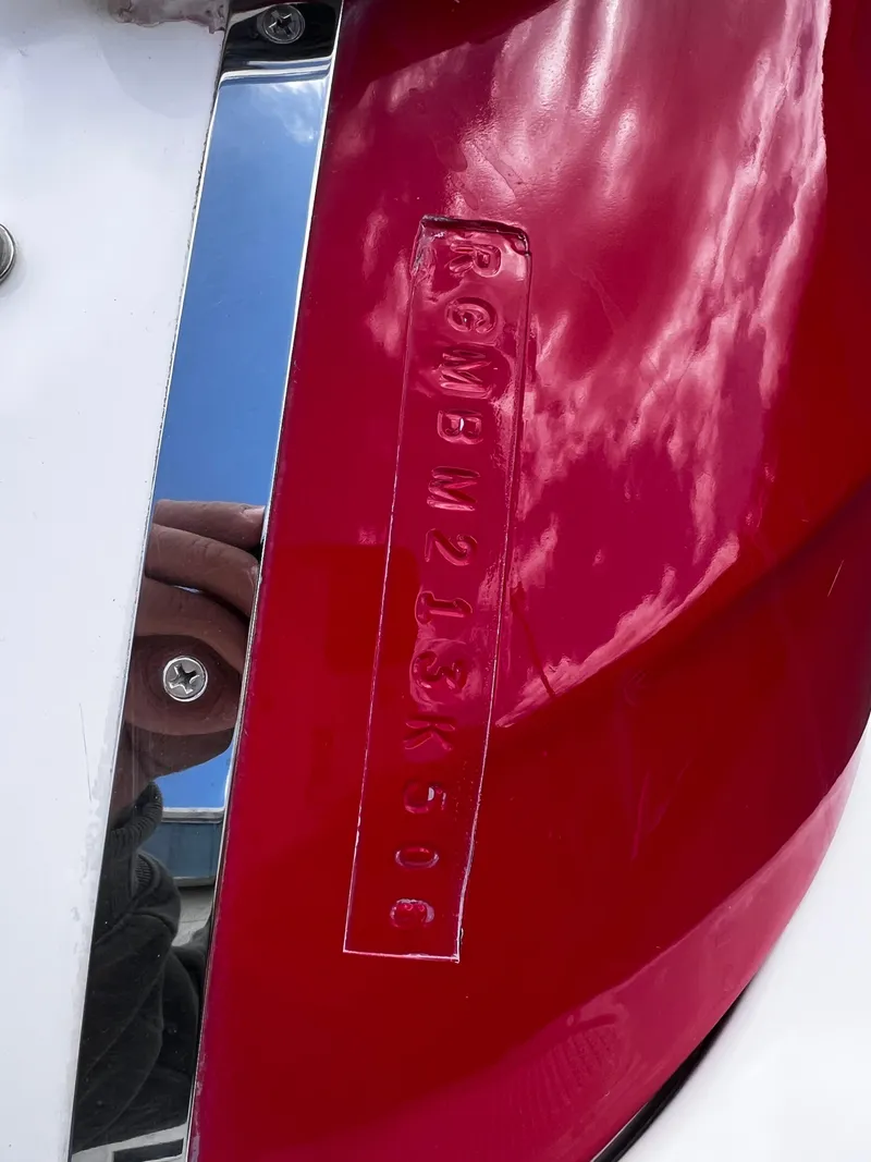 Slide: The Image of Close-up of a 2006 Regal 1900 Bowrider boat hull identification number on red surface. - 16