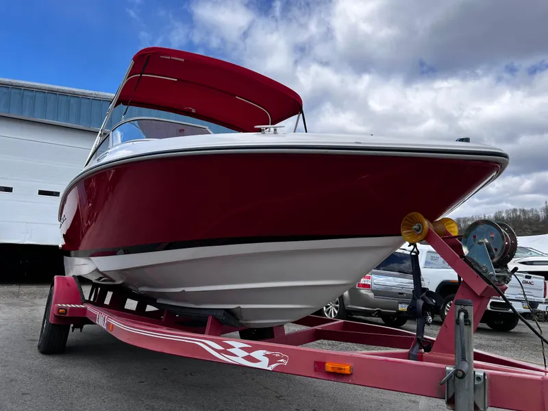 Slide: The Image of 2006 Regal 1900 Bowrider boat on trailer, red hull, parked outdoors. - 2
