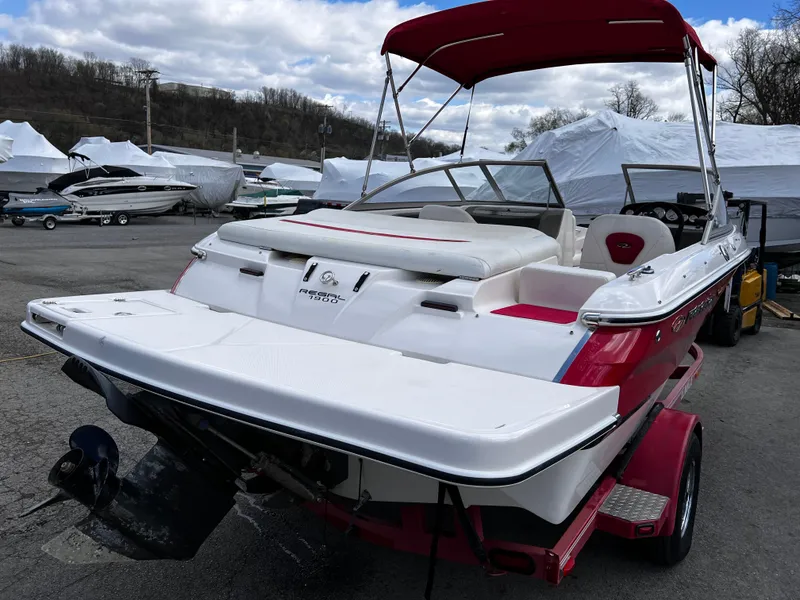 Slide: The Image of 2006 Regal 1900 Bowrider boat with red canopy, parked outdoors on a trailer. - 4