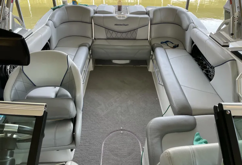 Slide: The Image of 2015 MasterCraft X23 boat interior with gray seating and carpeted floor. - 13