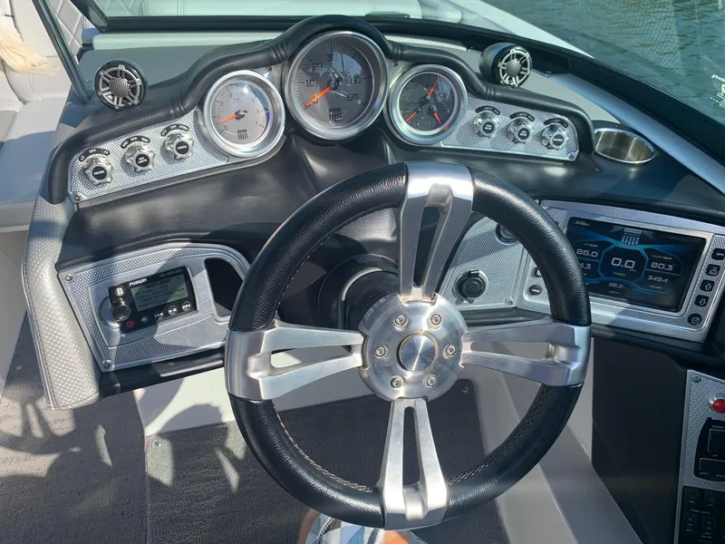 Slide: The Image of 2015 MasterCraft X23 boat dashboard with steering wheel and gauges. - 19