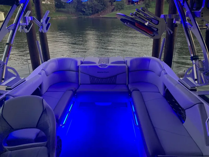Slide: The Image of 2015 MasterCraft X23 boat interior with blue LED lighting on a calm lake. - 21