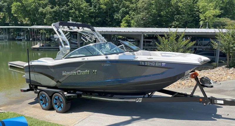 Slide: The Image of 2015 MasterCraft X23 boat on trailer by lakeside dock. - 3
