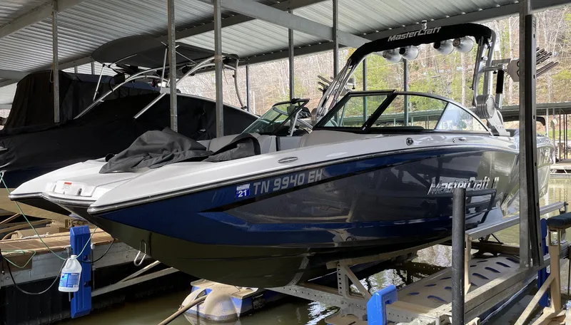 Slide: The Image of 2015 MasterCraft X23 boat docked under a covered marina. - 6